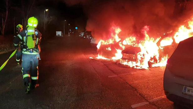 Feuerwehrmann neben brennenden Autos