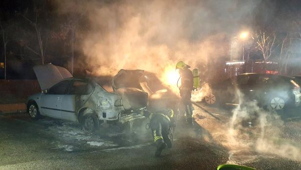 Feuerwehrmänner, die brennende Autos löschen und es ist sehr viel Rauch in der Luft