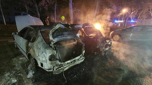 Zwei zerstörte Autos im Hintergrund Blaulicht und ein Feuerwehrmann
