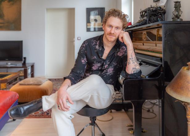 Lucas Fendrich sitzt an einem Klavier in einem Wohnzimmer.
