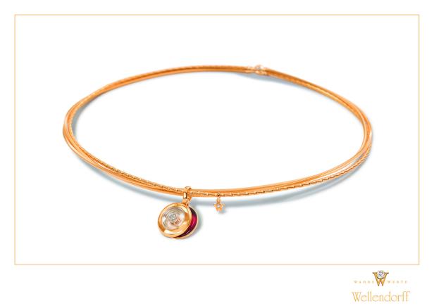 Ein goldenes Wellendorff-Collier mit einem runden Anhänger mit Diamanten.