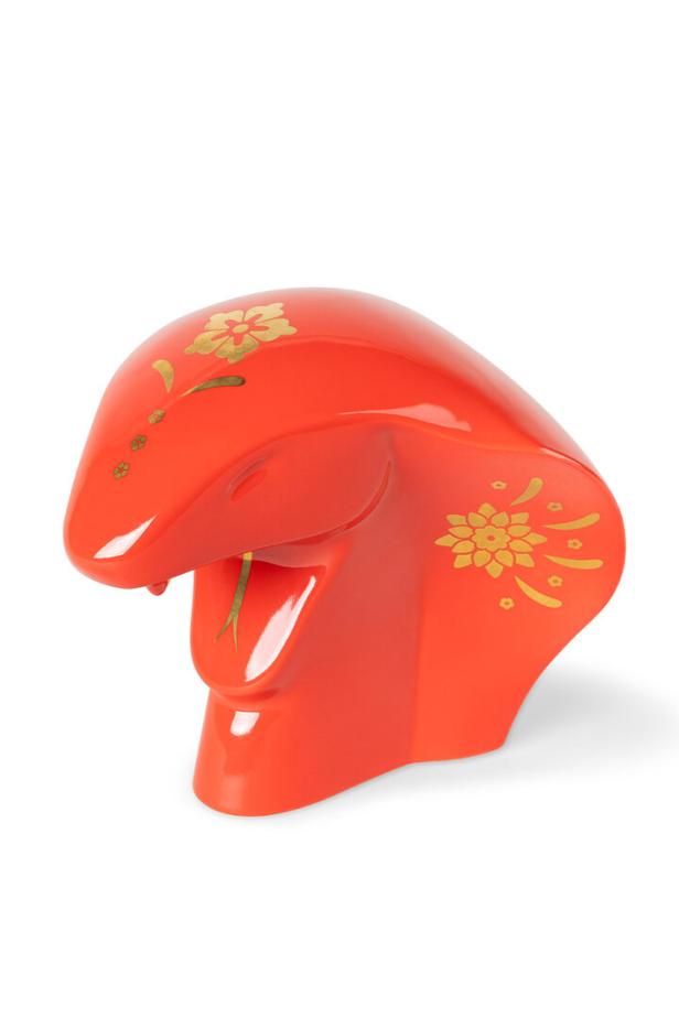 Eine rote, dekorative Schlangenfigur mit goldenen Blumenmustern.
