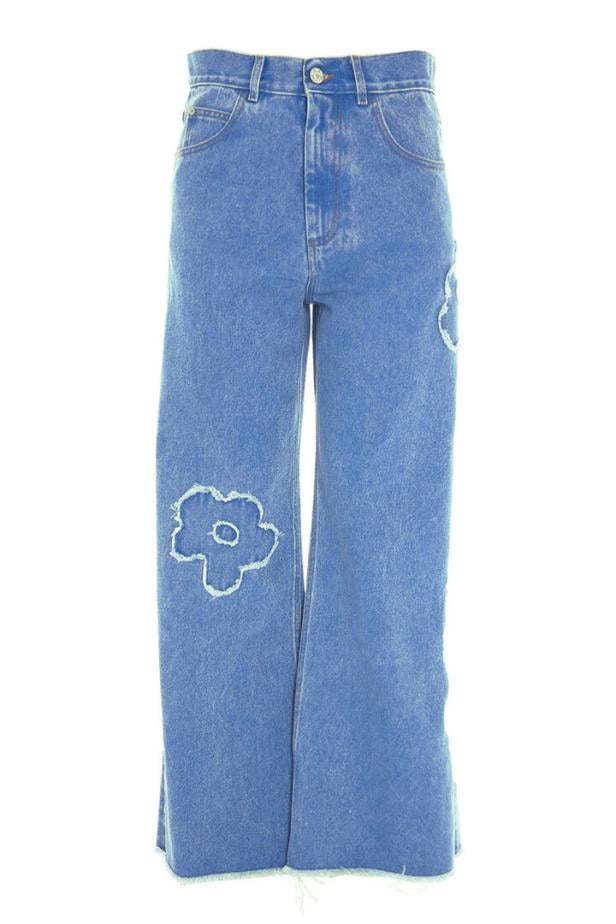 Eine hellblaue Jeans mit weitem Bein und aufgenähten Blumenapplikationen.
