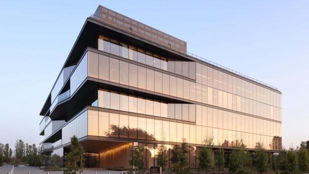 Ein modernes Bürogebäude mit Glasfassade und mehreren Ebenen.