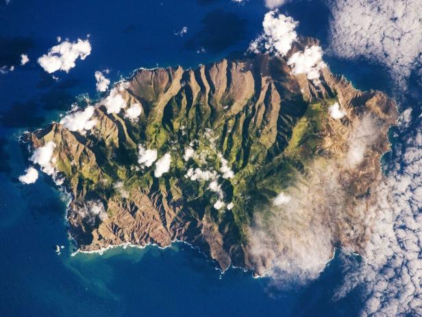Eine Luftaufnahme der Insel St. Helena mit Bergen und Küstenlinie.