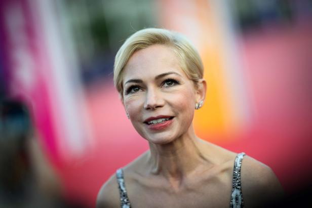 Michelle Williams lächelt auf einem roten Teppich.