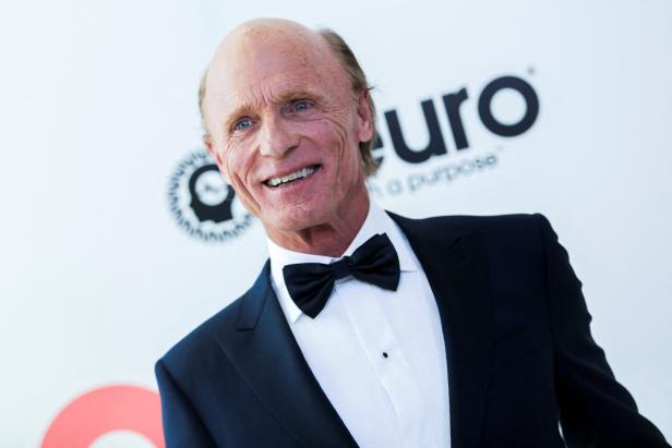 Ed Harris trägt einen Smoking und lächelt.