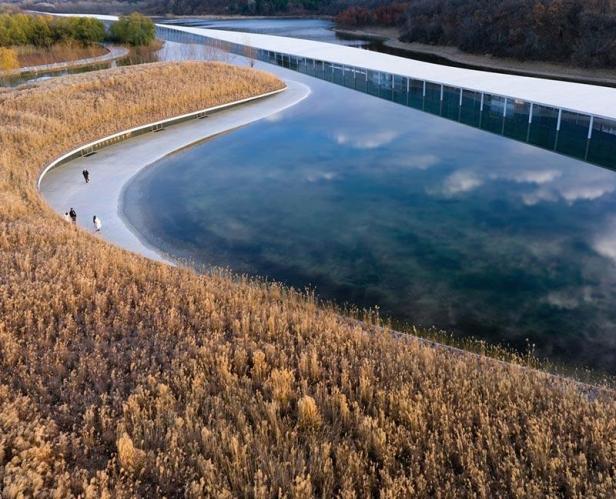 Das Zai Shui Art Museum von Junya Ishigami mit einem langen, weißen Gebäude über dem Wasser.