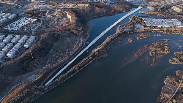 Luftaufnahme des Zai Shui Art Museum und einer langen, geraden Brücke in China.