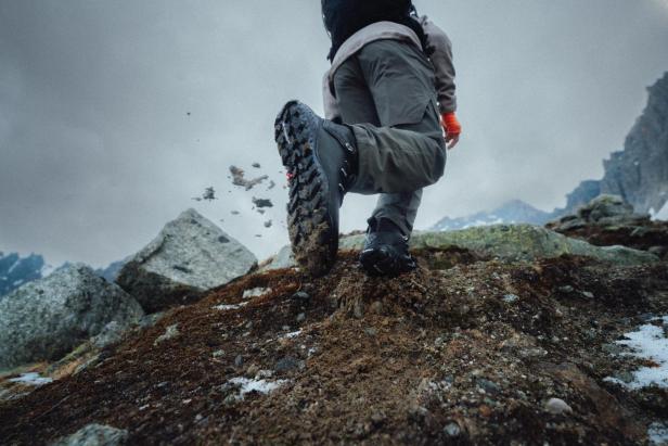 Eine Person wandert mit Wanderschuhen in den Bergen.