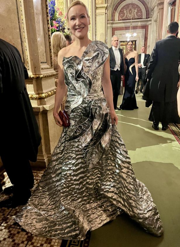 Eine Frau in einem silbernen Kleid auf einer Veranstaltung.