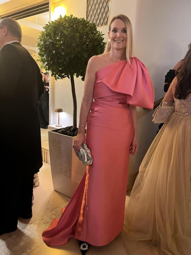 Eine Frau in einem rosa Abendkleid posiert für ein Foto.