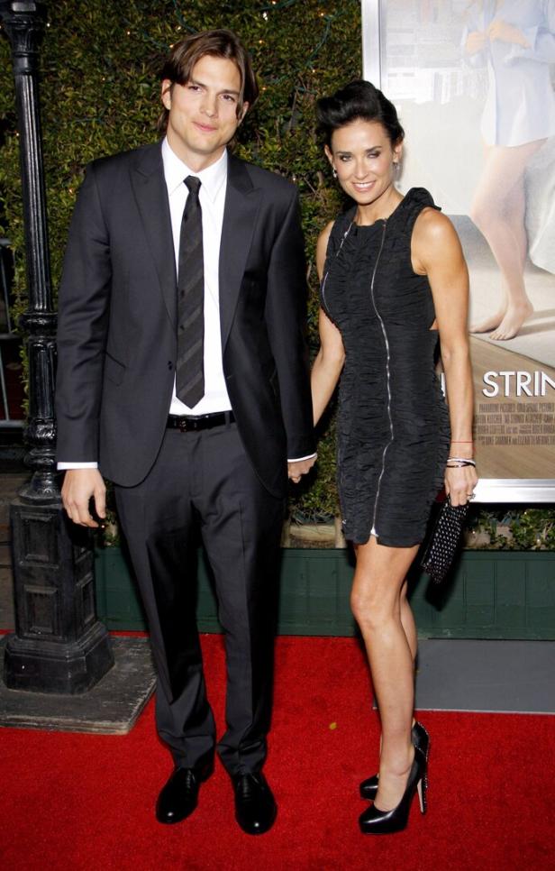 Ashton Kutcher und Demi Moore posieren auf einem roten Teppich.