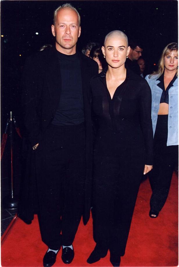 Bruce Willis und Demi Moore posieren auf einem roten Teppich.