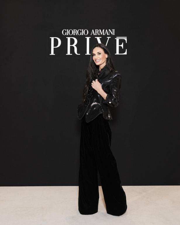 Demi Moore posiert vor einem Giorgio Armani Privé-Logo.