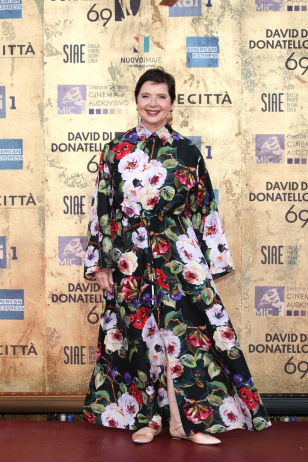 Isabelle Huppert in einem floralen Kleid auf dem roten Teppich.