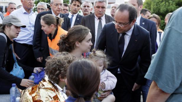 François Hollande trifft Überlebende eines Anschlags, die von Helfern betreut werden.