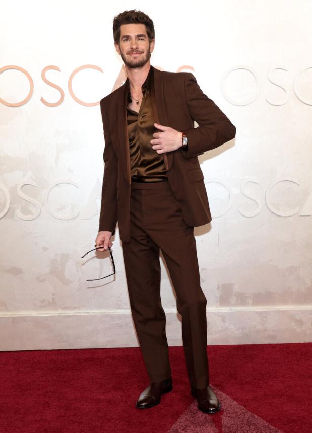 Andrew Garfield in einem braunen Anzug auf dem roten Teppich.