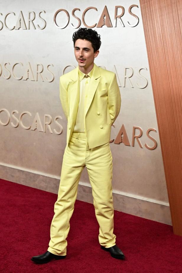 Timothée Chalamet auf dem roten Teppich der Oscars in einem hellgelben Anzug.
