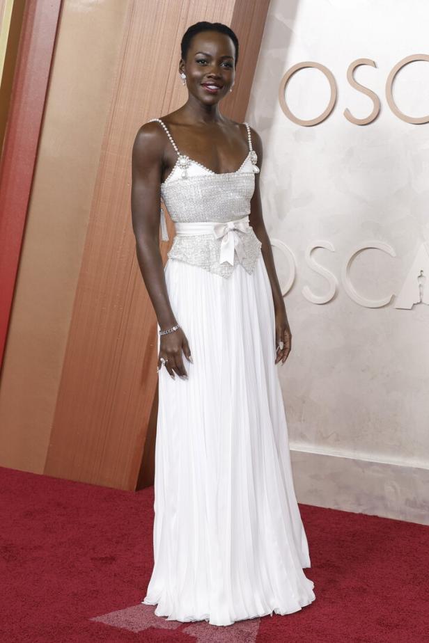 Lupita Nyong'o in einem weißen Kleid auf dem roten Teppich der Oscars.