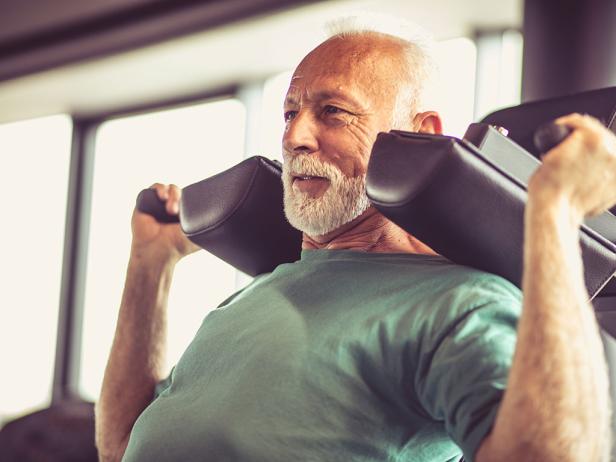 Ein älterer Mann mit weißen Haaren und weißem Bart im Fitnessstudio.