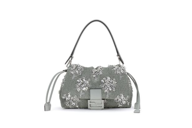 Eine graue Fendi Baguette Handtasche, verziert mit silbernen Blumenapplikationen.
