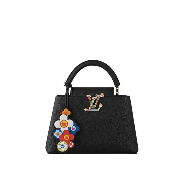Eine schwarze Louis Vuitton Capucines Handtasche mit bunten Blumenanhängern.