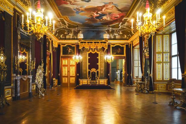 Ein barockes Schloss von innen mit goldenen Lichtern und Verzierungen.
