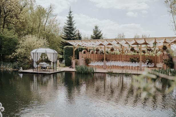Ein Pavillon und eine Hochzeitsbestuhlung spiegeln sich in einem Teich beim Winzerhotel Kolleritsch.