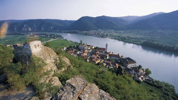 Blick auf Dürnstein in der Wachau mit der Donau und Weinbergen.