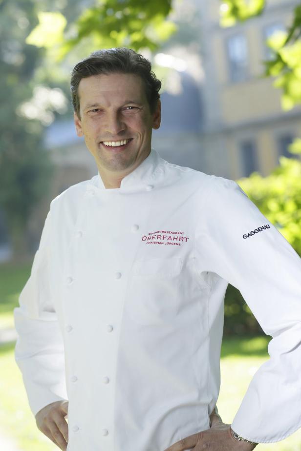 Ein lächelnder Koch Christian Jürgens im Garten des Restaurants „Überfahrt“.