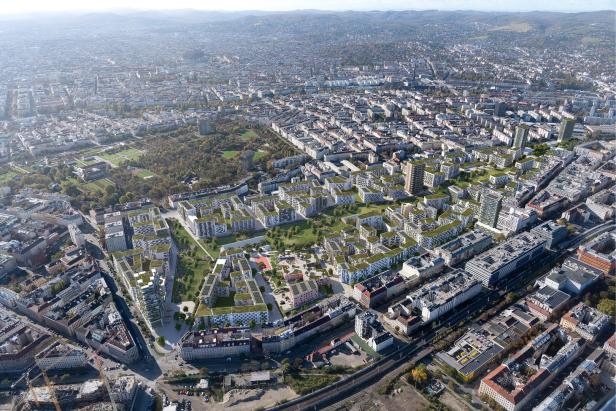 Stadtansicht des Wiener Nordwestbahnhofs mit vielen modernen Wohngebäuden, begrünten Dächern und großzügigen Grünflächen zwischen den Häusern.