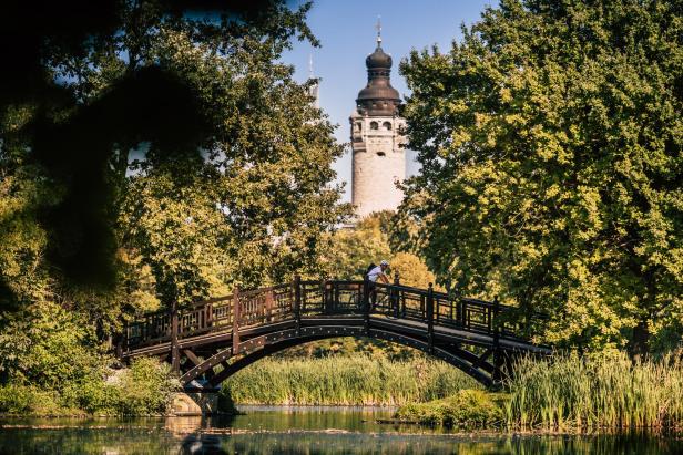 Ein Fahrradfahrer fährt über eine Brücke in einem Park.