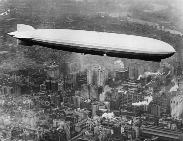 Ein Zeppelin in den 1920ern schwebt über den Hochhäusern New Yorks.