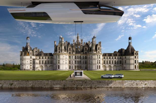 Das Luftschiff der AirYacht hält vorm Schloss Chambord in der Loire und lässt eine Kabine von oben hinab.