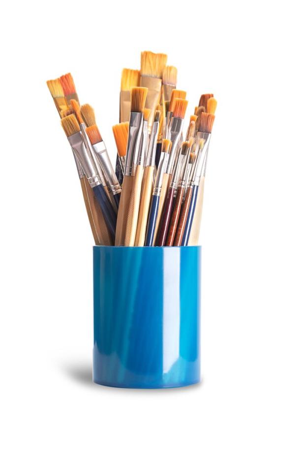 Viele Pinsel stehen in einem blauen Becher.