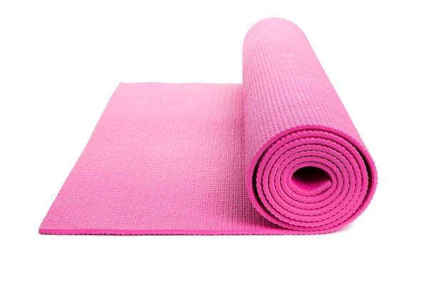 Eine teilweise ausgerollte, pinke Yogamatte liegt auf einem weißen Hintergrund.