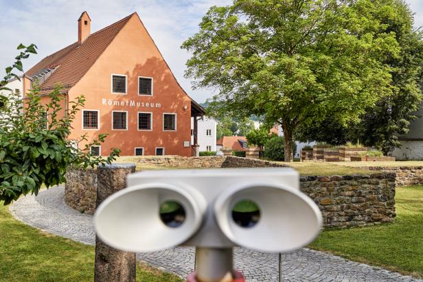 Ein rotes Einfamilienhaus mit einem Garten vornedran.