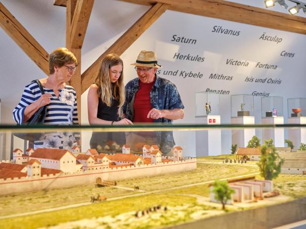Eine Familie steht vor dem Modell der Burg Passaus.