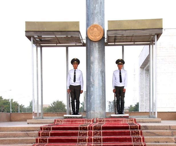 Zwei Soldaten in Uniform stehen Wache vor einem Denkmal.