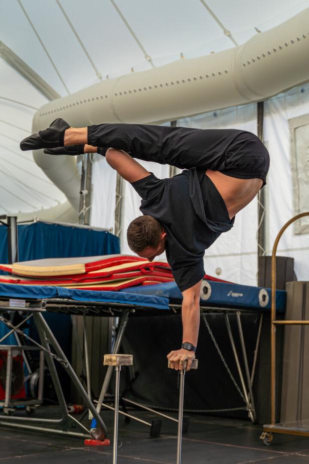 Ein Mann macht einen Handstand auf zwei kleinen Podesten.