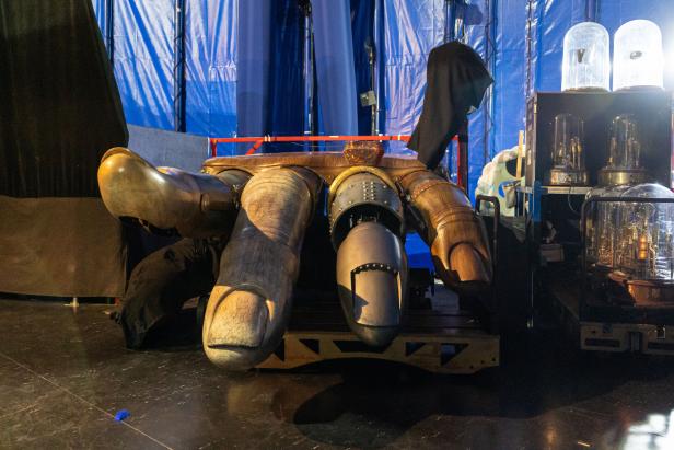 Eine überdimensionale, mechanisch anmutende Hand auf einer Bühne.