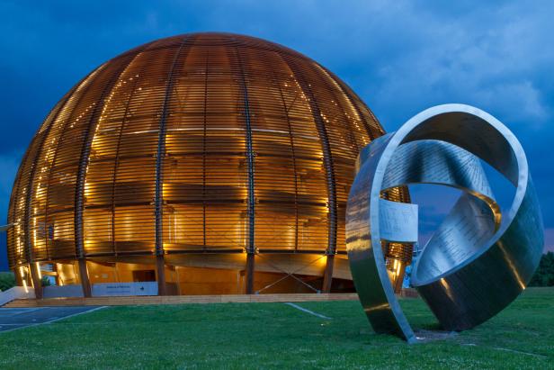 Das Globe of Science and Innovation am CERN mit einer Skulptur im Vordergrund.