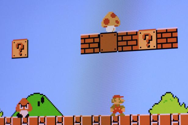Eine zweidimensionale Spieloberfläche. Der kleine Installateur Super Mario geht – neben ihm wartet ein grimmiger Pilz.