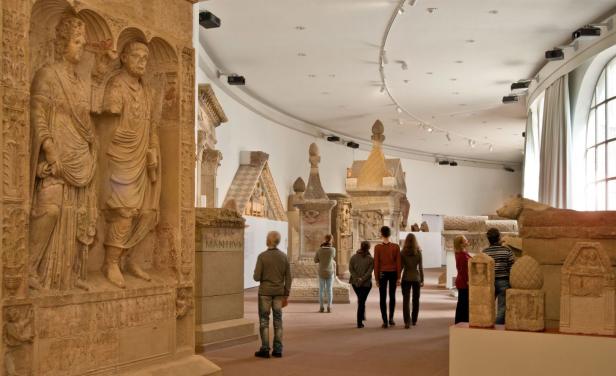 Personen laufen durch ein archäologisches Museum.