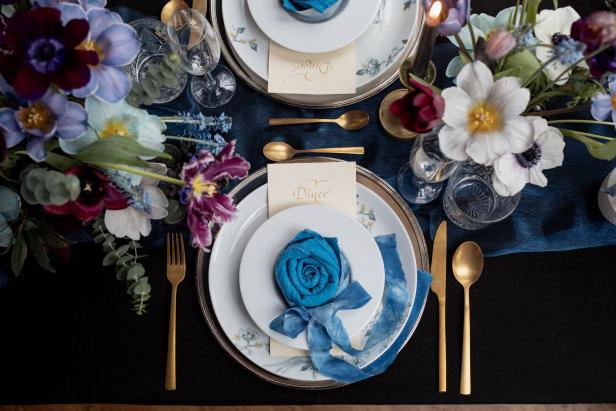 Ein festlich gedeckter Tisch mit Blumenarrangements und blauem Stoffservietten.