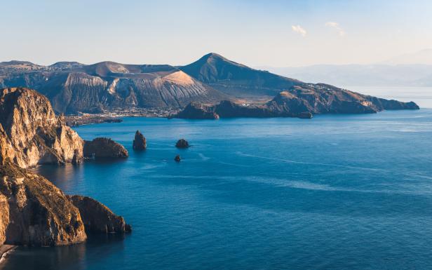 Blick auf die zerklüftete Küste und das blaue Meer der Insel Vulcano, Italien.