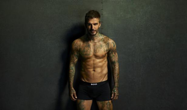 David Beckham posiert mit nacktem Oberkörper und Tattoos für eine Boss-Werbung.