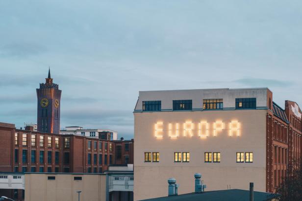 Ein Haus, auf dem das Wort „EUROPA“ leuchtet.
