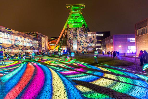 Die Zeche Zollverein in Essen ist nachts farbig beleuchtet.